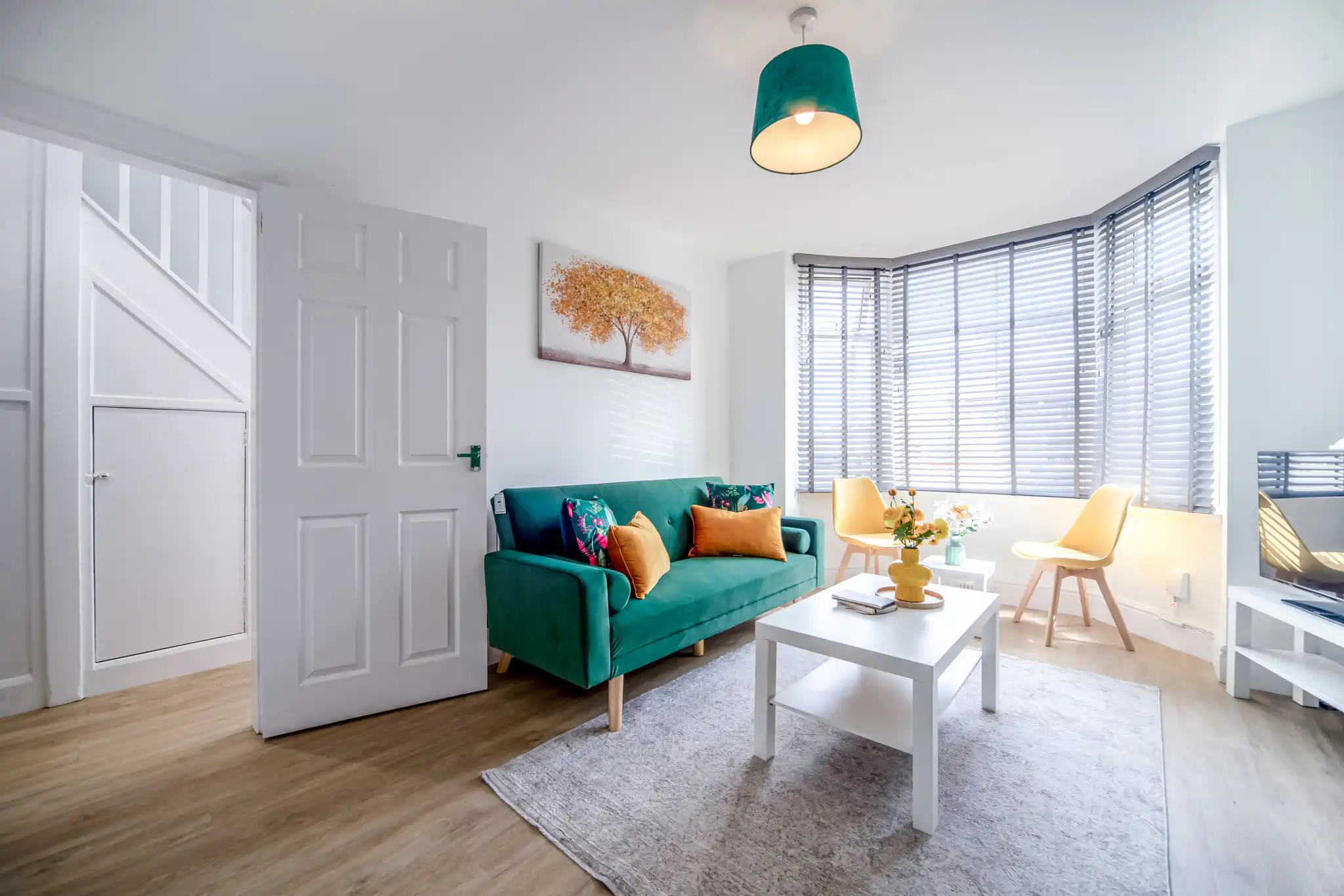 Bright living room with green sofa and bay window