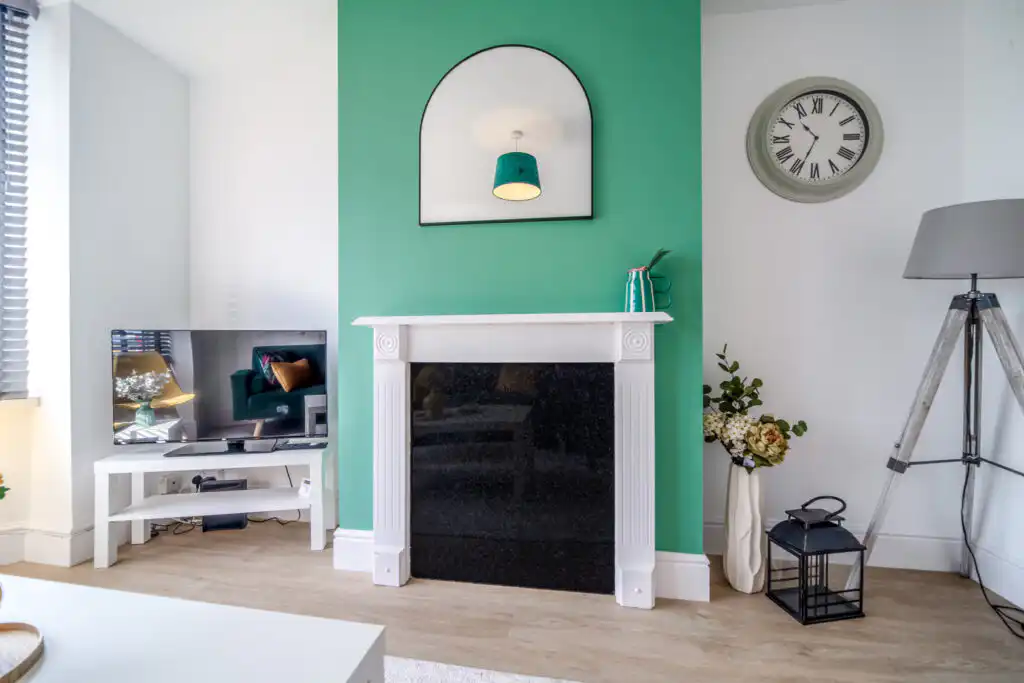 Modern living room with green accent wall and fireplace