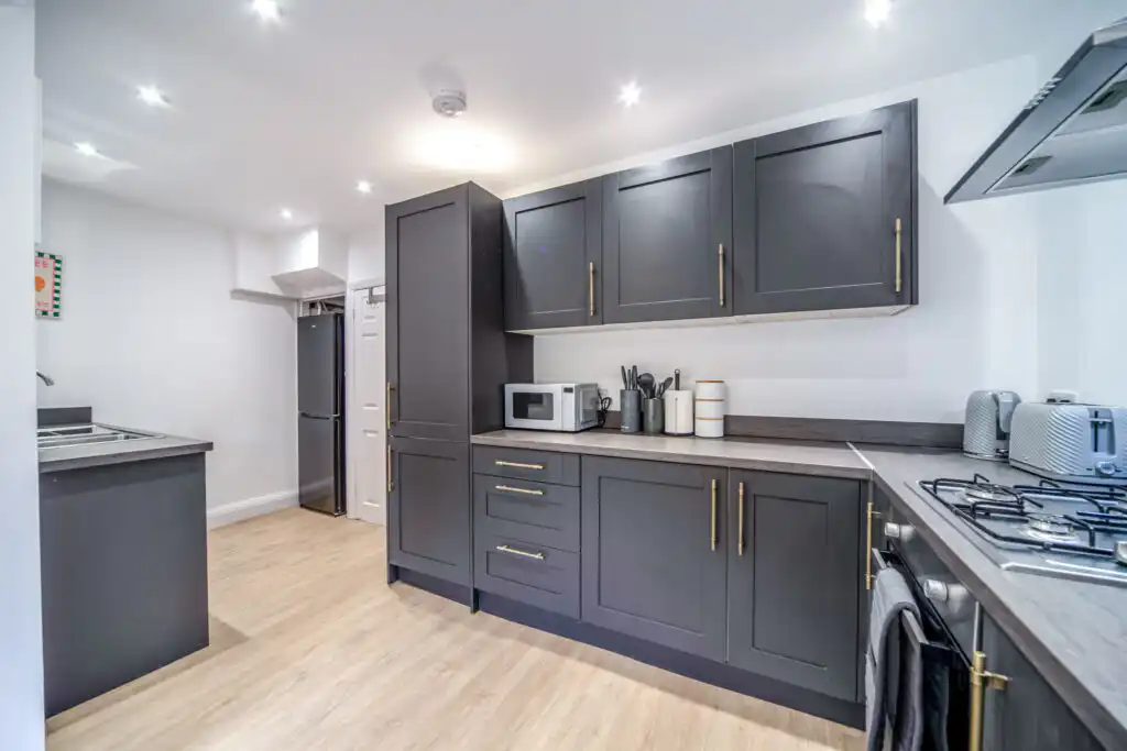 Modern kitchen with dark gray cabinets and brass handles