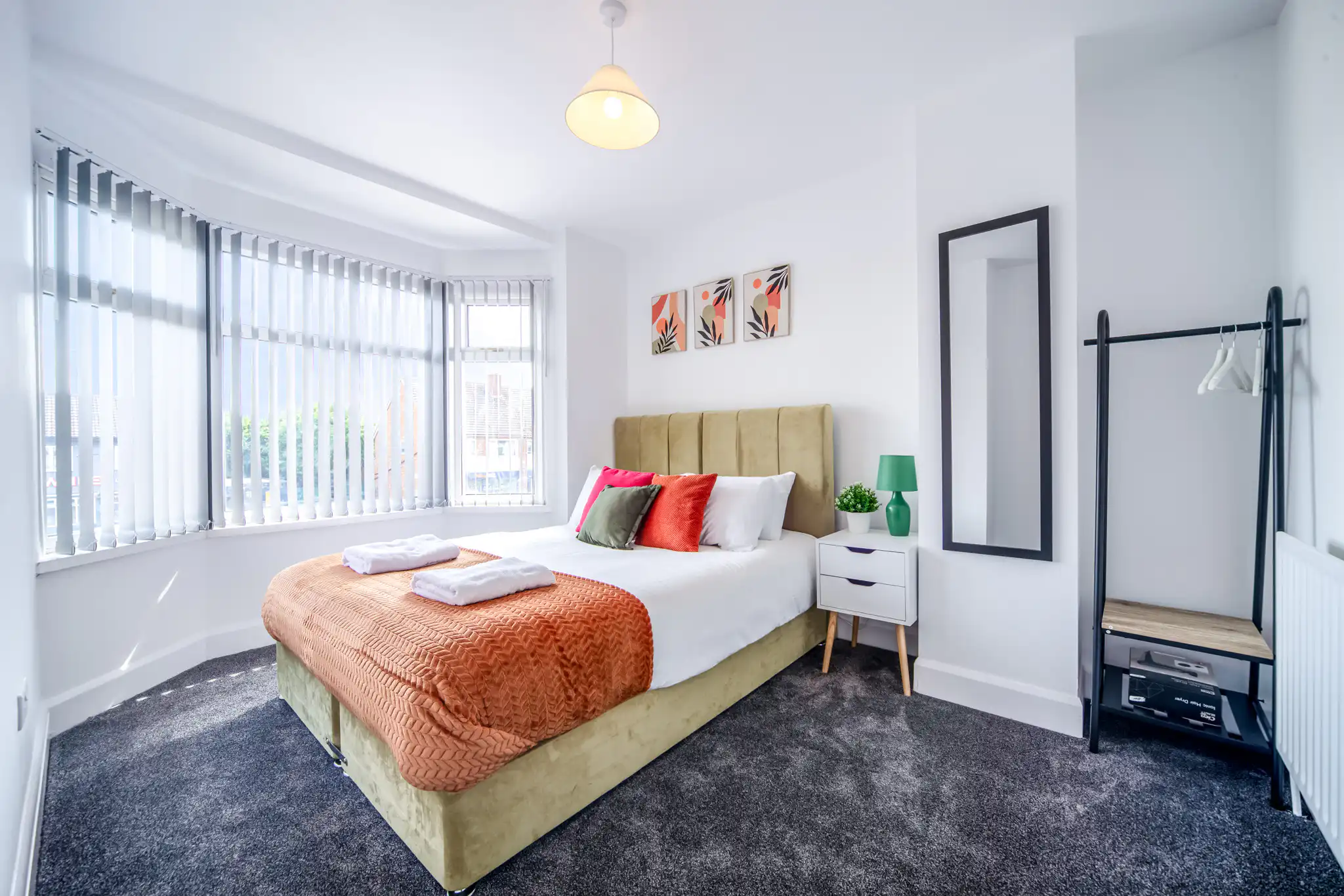 Bright modern bedroom with colorful accents and large windows