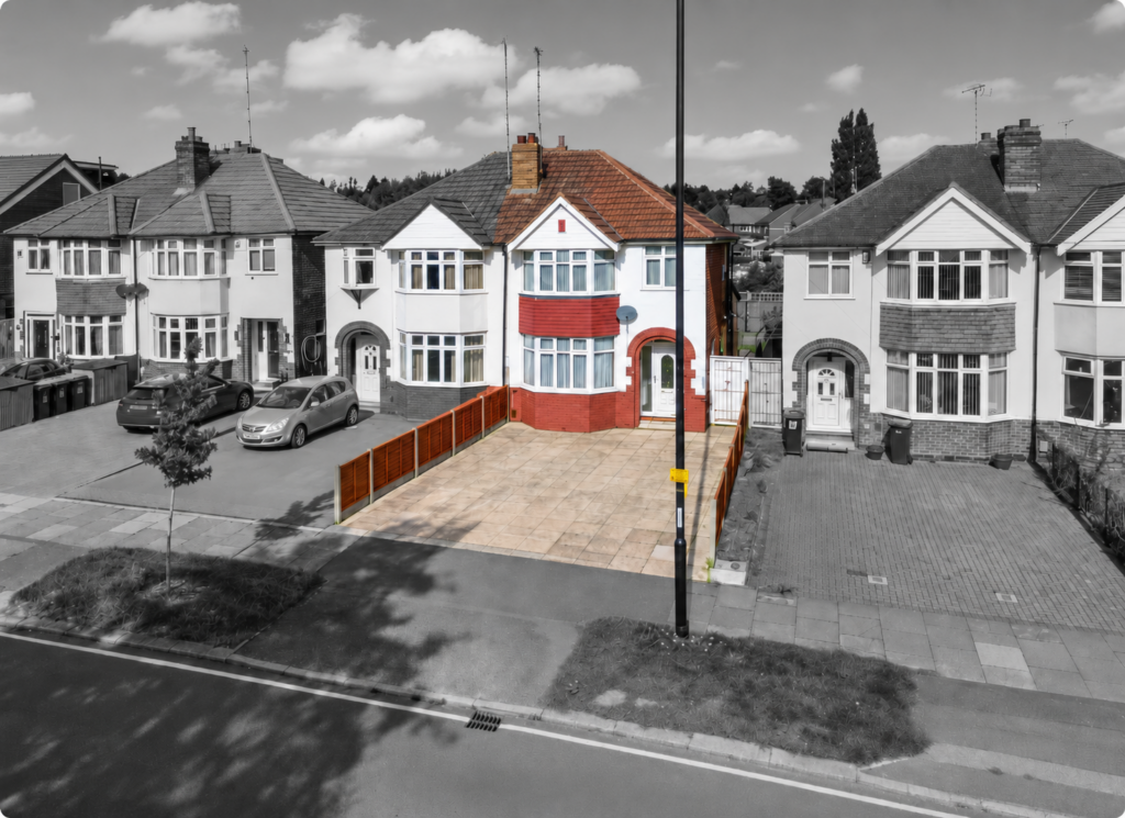 Red-accented suburban house with paved driveway and streetlamp