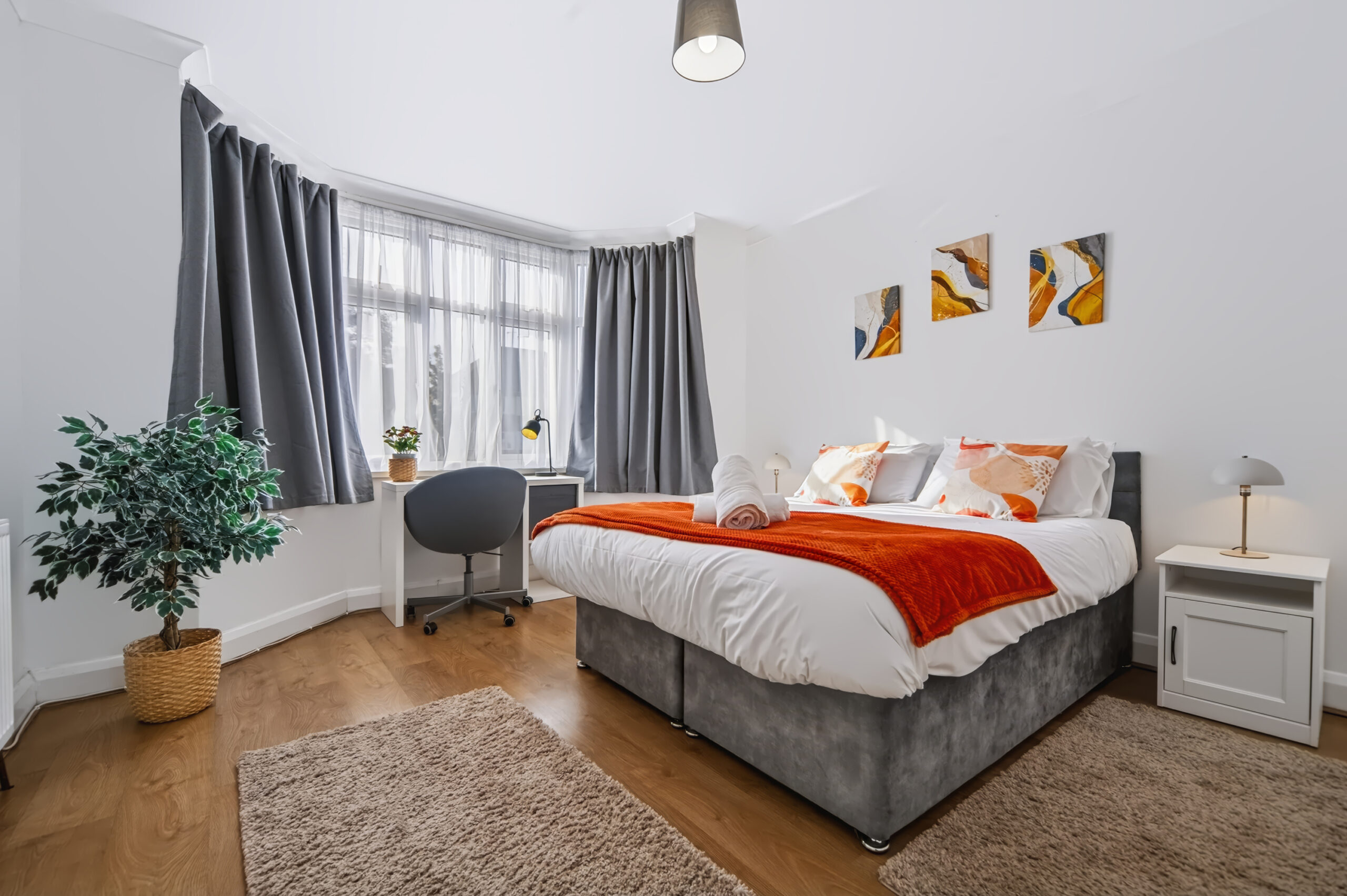 m_BEDROOM 1 VIEW 1 Bright modern bedroom with orange accents and workspace