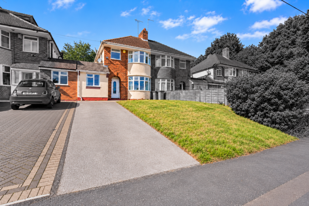 Semi-detached house with driveway, lawn, and blue front door